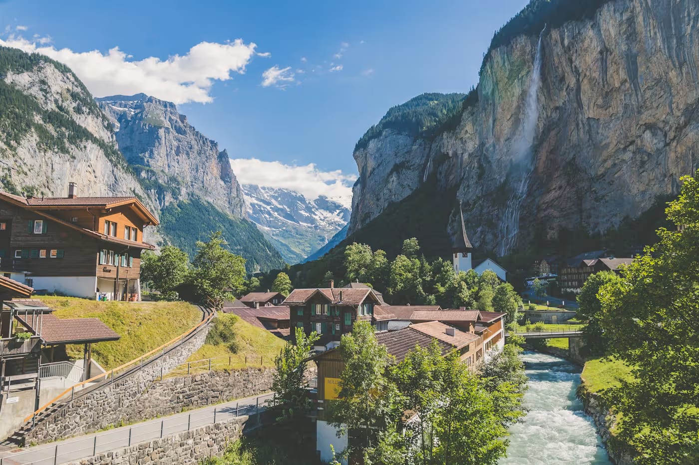Swiss valley village beneath sheer alpine cliffs